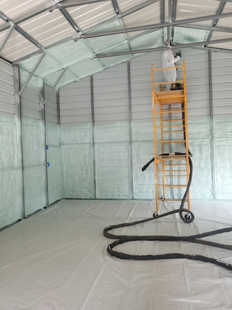 Technician installation spray foam insulation in roof and wall cavities